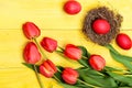 Bunch of flowers near pink Easter eggs in hay nest. Royalty Free Stock Photo