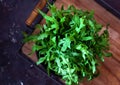 Bunch of fresh arugula leaves on a wooden tray. Top view