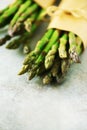 Bunch of fresh asparagus on gray backgrouns. Asparagus on craft paper with packthread. Raw, vegan, vegetarian and clean