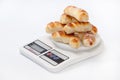 A bunch of fresh baked crescent rolls on a kitchen digital scale Royalty Free Stock Photo
