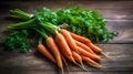 Bunch of fresh carrots with green leaves on wooden background.