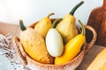 A bunch of colorful pumpkins in a hygge straw basket Royalty Free Stock Photo