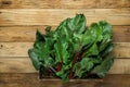 Bunch of fresh crispy green beet leaves in box on wood table background. Healthy vegan plant based diet vitamins. Eat your greens