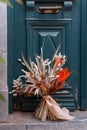 Bunch of fresh flowers with green leaves on the wooden door outside. Beautiful bouquet of tendy flowers decorated for