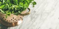 Bunch of fresh garden herbs in brass colander, copy space