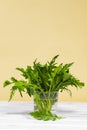 Bunch of Fresh green arugula salad on glass with water on a wooden table. Simple rustic background, antioxidant and healthy food, Royalty Free Stock Photo