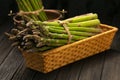 Bunch of fresh green asparagus spears in basket on a rustic wooden table Royalty Free Stock Photo