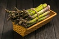 Bunch of fresh green asparagus spears in basket on a rustic wooden table Royalty Free Stock Photo