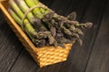 Bunch of fresh green asparagus spears in basket on a rustic wooden table Royalty Free Stock Photo