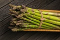 Bunch of fresh green asparagus spears in basket on a rustic wooden table Royalty Free Stock Photo