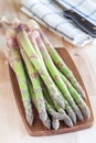 Bunch of fresh green asparagus on wooden board, vertical Royalty Free Stock Photo