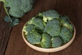 Bunch of fresh green broccoli on wood plate. Royalty Free Stock Photo