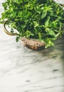 Bunch of fresh green garden herbs in brass colander