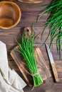 A bunch of fresh green onions on a cutting board on the table. Top and vertical view Royalty Free Stock Photo