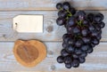 Bunch of fresh organic black grapes and a blank label tag on a wooden table Royalty Free Stock Photo