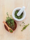 Bunch of fresh organic thyme in white mortar on wooden background Royalty Free Stock Photo