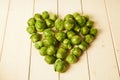 Bunch of fresh raw Brussel sprouts on a white wood table Royalty Free Stock Photo