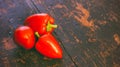 Bunch of fresh ripe red bell peppers on an old black wood grunge background Royalty Free Stock Photo