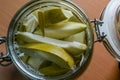 A bunch of fresh salted mango pieces in a glass jar with blurry background