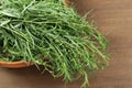 Bunch of fresh tarragon in bowl on wooden table, closeup Royalty Free Stock Photo