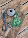 Bunch of fresh thyme, vintage scissors and skein of twine on cutting board