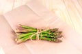 Bunch of fresh uncooked asparagus on wrapping paper