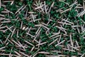 Bunch of galvanized self-drilling screws with washer and green hexagonal head, hardware background