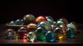 a bunch of glass marbles sitting on a wooden table next to a plate with a spoon in it and a black background behind them Royalty Free Stock Photo