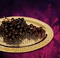 Bunch of grapes on hand carved hammered copper service tray, oriental grand bazaar gifts. Royalty Free Stock Photo