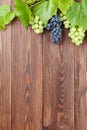 Bunch of grapes and vine on wooden table Royalty Free Stock Photo