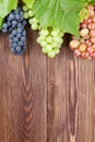 Bunch of grapes and vine on wooden table Royalty Free Stock Photo