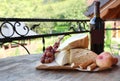 Bunch of grapes, wine, cheese and peaches on wooden table Royalty Free Stock Photo