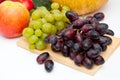 Bunch of Green and Black Grapes Fruits over white on Wooden Board Background Royalty Free Stock Photo