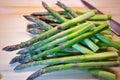 Bunch of green fresh asparagus or spargel in german on the choping plate with kitchen knife Royalty Free Stock Photo