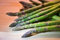 Bunch of green fresh asparagus or spargel in german on the choping plate with kitchen knife