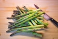 Bunch of green fresh asparagus or spargel in german on the choping plate with kitchen knife