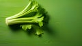 bunch of green fresh celery leaves on a green wooden background.