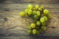 Bunch of green grapes on a light wooden tabletop