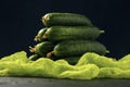 A bunch of green ripe cucumber fruits on the dark background. Vegetable pyramid composition on table Royalty Free Stock Photo