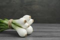 Bunch of green spring onions on grey wooden table, closeup. Space for text Royalty Free Stock Photo