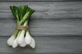 Bunch of green spring onions on grey wooden table, flat lay. Space for text Royalty Free Stock Photo