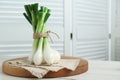 Bunch of green spring onions on white wooden table. Space for text Royalty Free Stock Photo