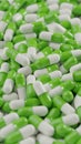 Bunch of green white capsule pills on a white background - Medicine healthcare medicaments - vertical