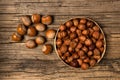 Bunch of hazelnut not purified and purified on old wood background.