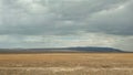 A bunch of hills stands out noticeably among the expanses of the steppe in cloudy weather. Royalty Free Stock Photo