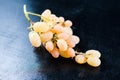 A bunch of homemade white grapes on a black wooden background Royalty Free Stock Photo