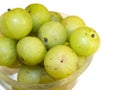 The bunch of Indian Gooseberry Phyllanthus emblica in a round glass bowl isolated on white background.