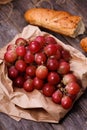A bunch of juicy large red grapes and fresh crispy wheaten baguette on a table of dark old wooden boards Royalty Free Stock Photo