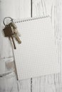Bunch of keys and notepad, wooden wall