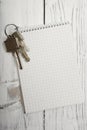 Bunch of keys and notepad, wooden wall Royalty Free Stock Photo